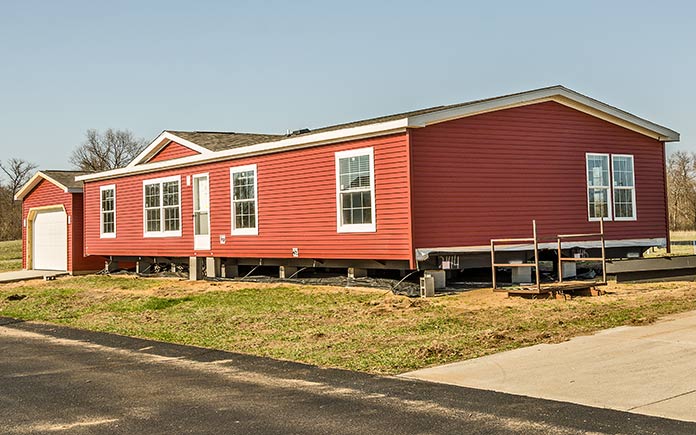 Casa modular roja recién instalada en tierra en el país