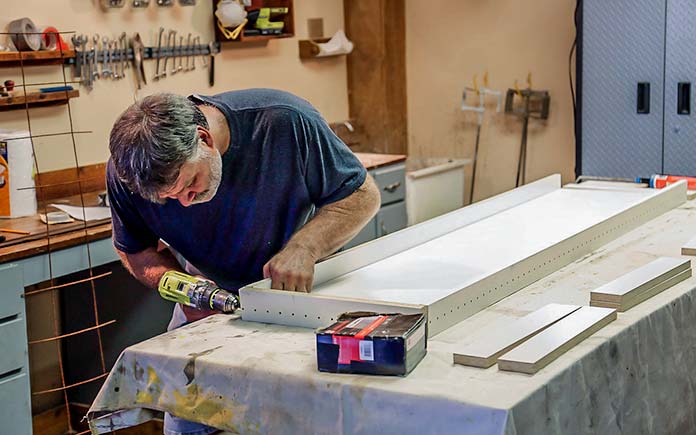 El hombre construye una forma de hormigón de melamina en su taller