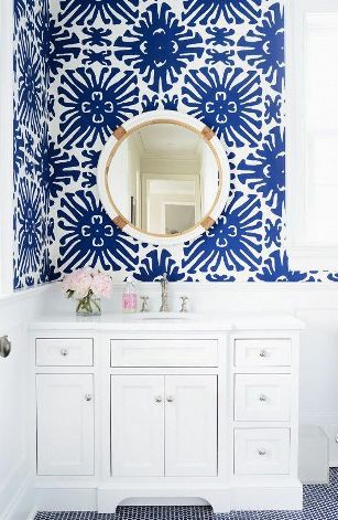 Un baño con papel tapiz azul claro. 