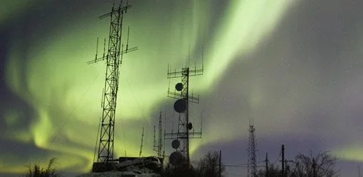 Aurora boreal sobre torres de comunicación